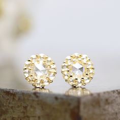 "This pair of 14k yellow gold stud earrings showcases natural rose cut diamond center stones surrounded by a sparkling white rose cut diamond halo. These gold earrings are the ultimate small everyday fancy luxury and are ready to ship. The 4mm center diamonds are a clear rose cut stone, beautifully cut and polished.  Surrounding the rose cut center stone are 10 small, natural white rose cut diamonds in each earring, for a total of 20. Each measures 1.5mm. The diamonds are prong set into the yell Formal Gold Cluster Earrings With Rose Cut Diamonds, Gift Cluster Earrings With Rose Cut Diamonds, Gift Rose Cut Diamond Cluster Earrings, Gold Diamond Earrings With Rose Cut Cubic Zirconia, Gold Cubic Zirconia Diamond Earrings With Rose Cut, Dainty White Gold Earrings With Rose Cut Diamonds, Dainty Rose Cut Diamond Earrings For Wedding, Dainty Rose Cut Diamond Wedding Earrings, Gold Sterling Silver Cluster Earrings With Brilliant Cut