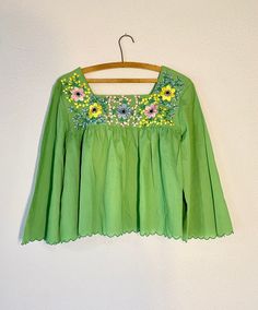 A beautiful 1970's green embroidered blouse. The perfect boho chic style. Cotton fabric. Condition: Good-Pre-owned. Please see pictures. Lay flat measurements: Shoulder to shoulder: 17.5 inches. Armpit to armpit: 20 inches. Waist: 24 inches. Length: 22 inches. Arm in-seam: 13 inches. Mahalo, Christina Green Long Sleeve Peasant Blouse, Green Embroidered Folk Blouse, Green Bohemian Blouse For Spring, Green Cotton Festival Blouse, Traditional Green Blouse For Spring, Spring Vintage Embroidered Top With Floral Embroidery, Vintage Floral Embroidered Top For Spring, Vintage Green Blouse For Spring, Green Long Sleeve Folk Top