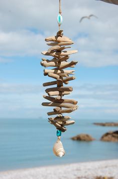 a wind chime made out of driftwood on the beach