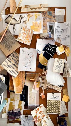 an assortment of art work displayed on a wooden table with white paint and brown paper