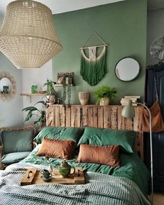 a bed with green sheets and pillows in a room