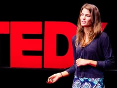 a woman standing in front of a ted sign