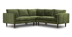 a green sectional couch with wooden legs