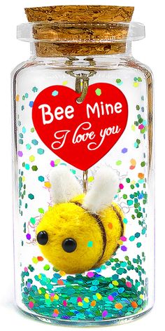 a glass jar with a stuffed animal in it's mouth and the words bee mine i love you