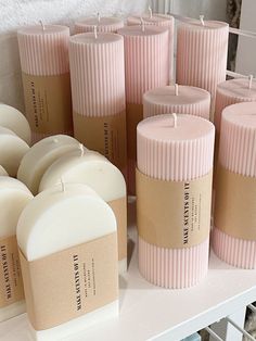 many pink candles are lined up on a shelf