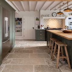 a kitchen with two stools next to an island