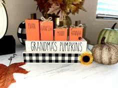 a table with pumpkins and decorations on it, including a sign that says grandma's pumpkins