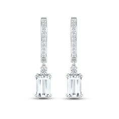 These mesmerizing earrings showcase a dangling emerald-cut white lab-created sapphire topped by a sparkling round white lab-created sapphire. The drop hangs from a sterling silver hoop adorned in more round white lab-created sapphires for all-over sparkle. The earrings secure with hinged backs. Modern Emerald Cut White Gold Earrings, Modern Baguette Cut White Diamond Earrings, Modern White Gold Emerald Cut Earrings, White Emerald Cut Baguette Diamond Earrings, Modern White Baguette Cut Diamond Earrings, White Gold Dangle Jewelry With Baguette Diamonds, White Gold Baguette Diamond Dangle Jewelry, Timeless White Diamond Dangle Earrings, White Emerald Cut Diamond Earrings With Accents