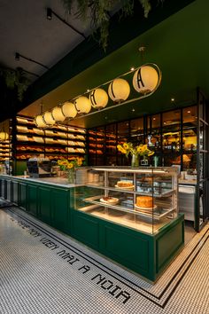 the interior of a restaurant with green walls and counters filled with pastries on display