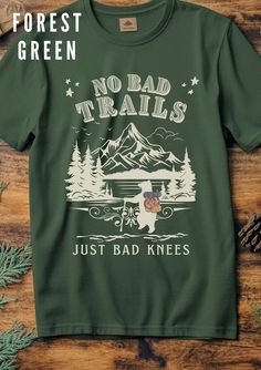 No Bad Trails Just Bad Knees Cute Bears Hiking T-Shirt | Retro 90s Forest Adventure Mountains Tee | Funny Teddy Bears T-Shirt Embrace your love for the outdoors with this charming "No Bad Trails Just Bad Knees" T-Shirt, featuring adorable teddy bears ready for a forest adventure! This vintage-inspired tee is perfect for hikers, nature lovers, or anyone with a sense of humour. The retro 90s design showcases a scenic mountain backdrop with cute bears, making it a must-have for your next hiking tri Funny Teddy Bear, Cheap Bear Print Graphic Tee, Bear Design Graphic Tee With Short Sleeves, Mountain Tee, Casual Bear Design Short Sleeve T-shirt, Bad Knees, White Short Sleeve T-shirt With Bear Print, Forest Adventure, Hiking Tshirt