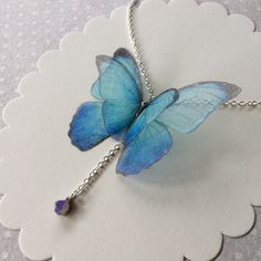 I'm in love with blue Morpho butterflies and Opals. This is a delicate and dainty creation, that celebrate my love for them. The silk organza butterfly measure about 5 cm wingspan. Silver Plated 925 chain is available in 40 cm (16 inches), 45 cm (18 inches) or more, you can choose! Closed with lobster clasp. Nickel free. The necklace pictured is long 40 cm (16 inches) and it's already sold. The pendant is a natural raw polished BLUE and GREEN Ethiopian Welo Opal that measures about 4 mm and is a Bohemian Butterfly Charm Necklace As A Gift, Bohemian Butterfly Charm Necklace For Gift, Bohemian Butterfly Necklace With Charm As Gift, Bohemian Butterfly Necklace As A Gift, Bohemian Butterfly Necklace For Gifts, Dainty Blue Butterfly Jewelry, Whimsical Blue Necklace For Gifts, Whimsical Blue Necklace For Gift, Blue Butterfly Necklace For Gifts