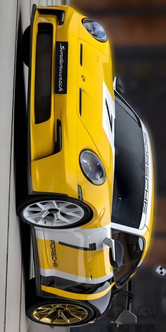 a yellow car hanging from the side of a building