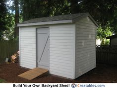 a white shed sitting in the middle of a yard