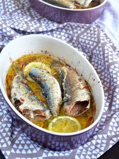 two bowls filled with fish on top of a table