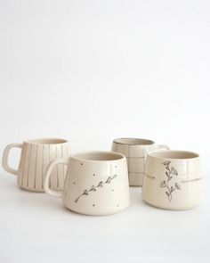 three mugs with designs on them sitting next to each other