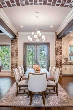 the dining room table is surrounded by white upholstered chairs and an ornate chandelier