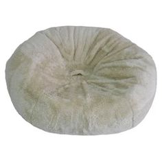 a white round dog bed with fur on it's back and side, sitting in front of a white background