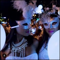 two women wearing masks and pearls are posing for the camera