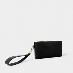 The Zana Fold Out Wristlet Wallet is an elevated style that features a classic, minimal design with vegan leather details, gold-tone hardware and a detachable keychain. While the interior includes a wide note slot and zip compartment to store all of your small essentials. The ultimate day-to-night accessory. Details Color: Black Dimensions: 4.375" x 0.75" x 7.5" Strap Length: 15" Fold Out Wristlet Wallet by Katie Loxton Modern Clutch With Wrist Strap For Daily Use, Everyday Coin Purse With Wrist Strap, Everyday Coin Purse Clutch With Wrist Strap, Chic Wallets With Zipper Closure For Everyday, Chic Everyday Wallet With Zipper Closure, Classic Everyday Clutch With Wrist Strap, Modern Wallets With Wrist Strap For Daily Use, Chic Leather Wristlet For Everyday, Chic Everyday Leather Wristlet