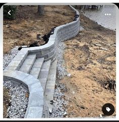 an image of a stone wall being built in the yard with rocks and gravel around it