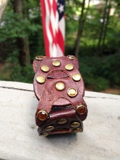 Made from a cool detailed leather belt, a handmade and unique cuff. This bracelet has all the right bling, sparkly amber colored jewel grommets. Yes one of the amber colored jewels is missing, but that just adds to the recycled worn look of the bracelet. You can see the missing jewel in the first picture. It in no way takes away from the bracelet. 7 inches long 1 & 1/4 inches wide Vintage Brown Leather Fashion Bracelet, Vintage Jewelry With Leather Strap, Brown Leather Cuff Jewelry, Vintage Leather Bracelet With Rivets, Vintage Leather Bracelets With Rivets, Leather Jewelry With Rivets For Gifts, Vintage Adjustable Leather Bracelet With Rivets, Leather Jewelry With Rivets As A Gift, Vintage Leather Bracelet Jewelry