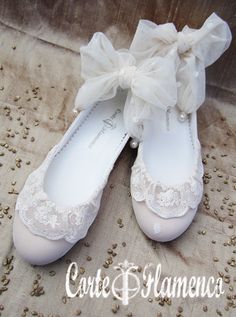 pair of white shoes with lace and bows on them