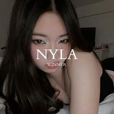 a woman laying on top of a bed next to a white wall with the words nyla written across it