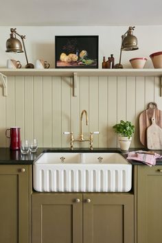 a kitchen with green cabinets and white sink