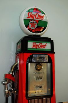 a red and black machine sitting on top of a table next to a white wall