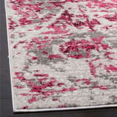 an area rug with pink and gray flowers on it