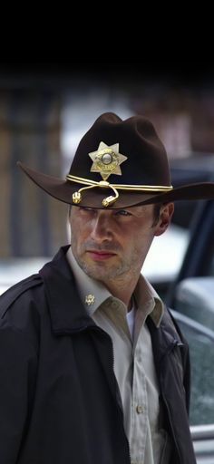 a man wearing a hat with a star on it and a sheriff's badge