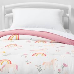 a bed with white sheets and pink pillow cases