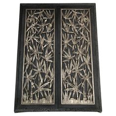 an intricately designed metal door with bamboo leaves on the outside and side paneling