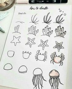 a sheet of paper with drawings of sea animals and jellyfishs on it next to a marker pen