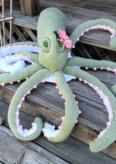 an octopus stuffed animal sitting on top of a wooden bench