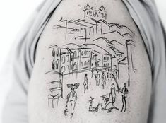 a man's arm with a drawing on it and people walking down the street