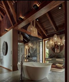 a large white bath tub sitting inside of a bathroom next to a wooden ceiling and windows