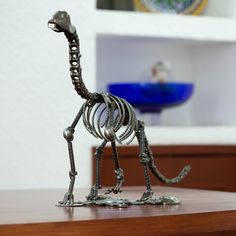 a metal giraffe figurine sitting on top of a wooden table