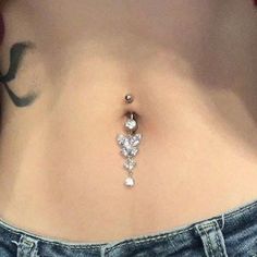 a woman's stomach with a diamond belly ring attached to the bottom of it