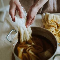 a woman is cleaning the inside of a pot with a cloth on top of it