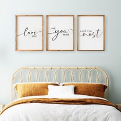 a bed with two framed pictures above it and the words love you most on them