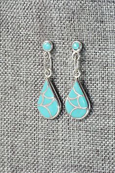 These turquoise and sterling silver inlay earrings were made by Zuni silversmith Orena Leekya.Length: 1 1/4"Width: 1/2"Free shipping on all orders! We ship with USPS and always include tracking. All orders ship within a day of payment.Returns are accepted up to 30 days after you receive your order. Just send us a message. Our shop offers cash back or store credit. The item must be returned in new condition. Blue Sterling Silver Earrings With Inlay, Unique Blue Earrings With Inlay, Unique Blue Inlay Earrings, Turquoise Sterling Silver Pierced Earrings, Turquoise Inlay Earrings Gift, Turquoise Inlay Earrings As Gift, Turquoise Inlay Sterling Silver Jewelry, Sterling Silver Turquoise Inlay Jewelry, Silver Dangle Earrings With Inlay