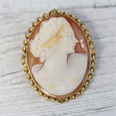 HERE ARE THE DETAILS YOU NEEDN6014Antique 14K Yellow Gold Carved Shell Cameo Brooch Pendant Pretty Lady LuxuryBEAUTIFUL LADY WITH HEADRESS, EARRINGS HAND CARVED SHELL CAMEO. FINEST DETAIL AMAZING BROOCH PIN WONDERFUL HIGHEST QUALITY. JUST PART OF MY MOST RECENT ESTATE FINDS! FOLLOW ME TO SEE THEM ALL! Metal Purity: Metal: 14K Yellow GoldMaterial: Carved Shell CameoForm: Brooch Pendant Pretty Lady LuxurySize :1 3/4 x 1 1/2"Age: AntiqueWeight (Grams): 11.8IT IS IN VERY FINE ESTATE CONDITION Luxury Gold Brooches With Cabochon, Classic Cameo Brooches For Wedding, Classic Gold Brooch With Intaglio Detail, Classic Gold Intaglio Brooch, Heirloom Cabochon Brooches For Formal Occasions, Heirloom Brooches With Cabochon For Formal Occasions, Classic Gold Intaglio Brooches, Luxury Yellow Gold Cameo Brooch, Classic Gold Brooches With Intaglio