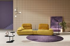 a living room with two yellow chairs and a purple rug