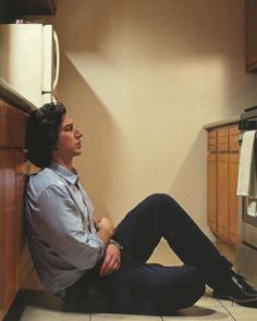 a man sitting on the floor in a kitchen