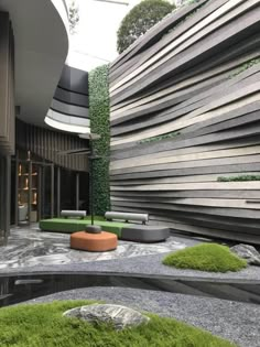 an outdoor area with grass and rocks on the ground, surrounded by wooden slats