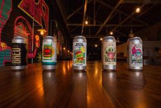 six cans of beer sitting on top of a wooden floor