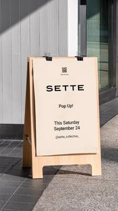 a sign sitting on the sidewalk in front of a building that says sette pop up