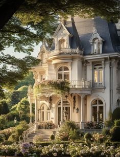 a large white house surrounded by trees and flowers