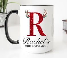 a coffee mug with the letter r on it and reindeer antlers around its neck